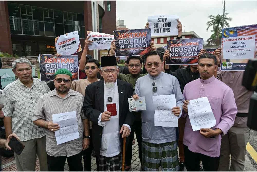 Mohd Azmi (tengah) menunjukkan memorandum bantahan berhubung tekanan yang diberikan oleh ahli Kongres AS ke atas dasar kedaulatan Malaysia di hadapan Kedutaan AS di sini, hari ini. - Foto: Bernama