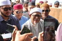 Abdul Hadi (tengah) ditemui pemberita selepas menyampaikan kuliah duha di Masjid Rusila, Marang pada Jumaat.