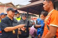 Garry Belayong (kiri) dan pegawai bertugas memeriksa kad UNHCR yang dipercayai palsu semasa Ops Mega di sekitar Bandar Kota Bharu pada Jumaat. Foto: HAZELEN LIANA KAMARUDIN