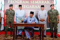 Anwar menandatangani buku selepas menghadiri Program Semarak Kenegaraan di Hangar Pusasda Port Dickson hari ini. - Foto: Bernama