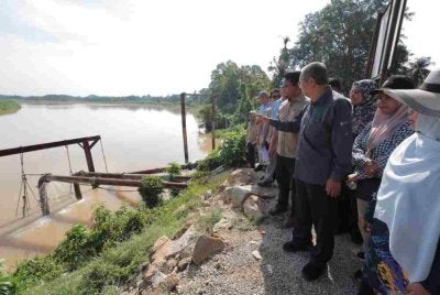 Mohammad Nizar (tiga dari kanan) meninjau paras air Sungai Perak ketika lawatan ke Rumah Pam Teluk Bakong, Parit pada Jumaat.