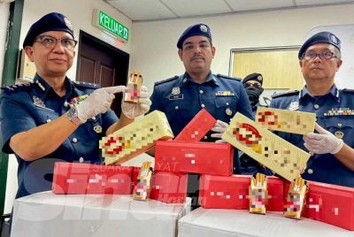 Hasbollah (kiri) menunjukkan sebahagian rokok seludup bernilai RM9.14 juta yang dirampas pada sidang media Jumaat.