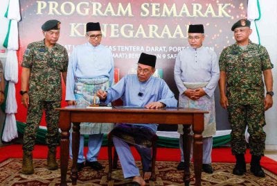 Anwar menandatangani buku selepas menghadiri Program Semarak Kenegaraan di Hangar Pusasda Port Dickson hari ini. - Foto: Bernama