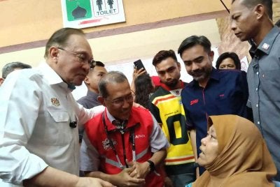 Muhammad Nazri (dua dari kiri) bersama Perdana Menteri, Datuk Seri Anwar Ibrahim berkesempatan menyantuni seorang Orang Kurang Upaya (OKU), Jumaah Mohd Alif, 68 yang tidak ketinggan hadir pada program di Benteng @ Medan Selera Ampangan.