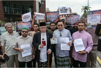 Mohd Azmi (tengah) menunjukkan memorandum bantahan berhubung tekanan yang diberikan oleh ahli Kongres AS ke atas dasar kedaulatan Malaysia di hadapan Kedutaan AS di sini, hari ini. - Foto: Bernama
