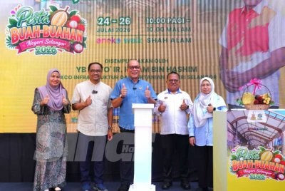 Izham (tengah) melakukan gimik perasmian semaa Majlis Majlis Perasmian Festival Buah-buahan Tempatan Selangor di Aneka Walk, Seksyen 13 di sini pada Jumaat. Foto SINAR HARIAN/MOHD HALIM ABDUL WAHID