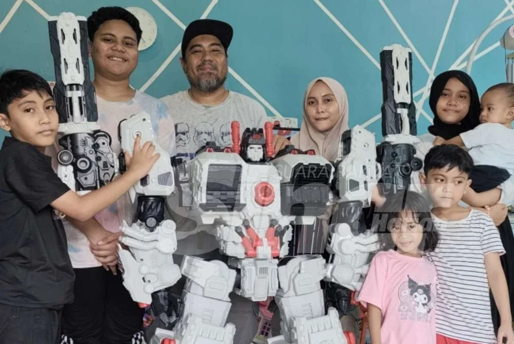 Mohd Asraf bersama isteri dan enam anaknya bergambar dengan figura Metroplex yang akhirnya tiba di rumahnya selepas penantian lebih dua tahun.