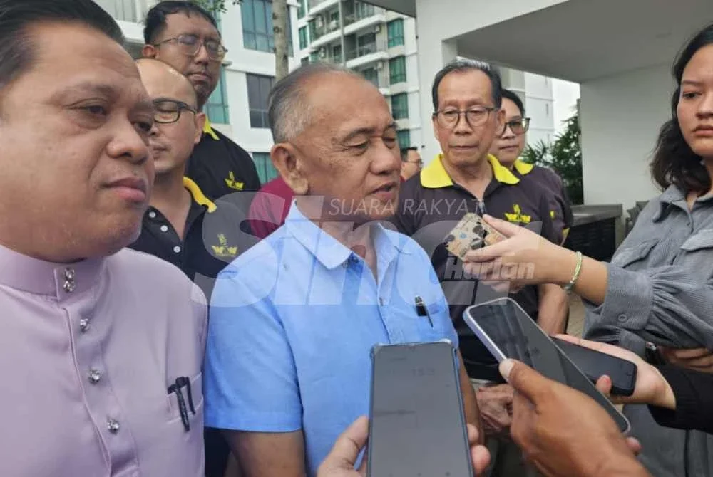 Awang Ahmad Sah (tengah) bersama penduduk ketika ditemui pemberita. 