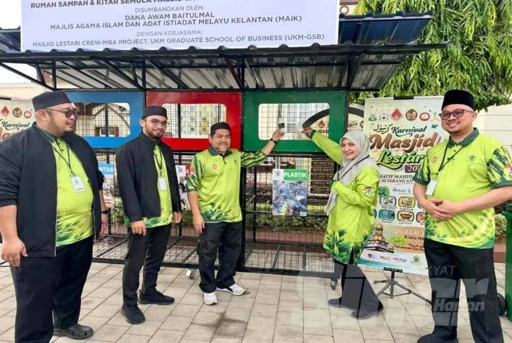 Dr Mazllida (dua dari kanan) dan Ridwan (tiga dari kiri) membuang botol dan cawan plastik ke dalam ruangan kitar semula. FOTO ADILA SHARINNI WAHID