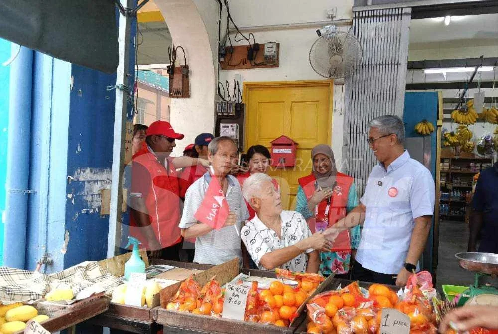 Tengku Zafrul (kanan), Noorzunita (dua kanan) berkesempatan beramah mesra dengan penduduk Pekan Kuala Pilah ketika Program Walkabout pada Sabtu.
