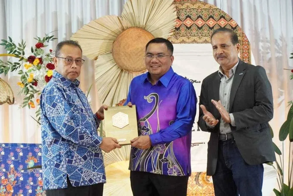 Abdul Fattah (kiri) menyampaikan cenderamata kepada Amizar diiringi Balu Iyer.