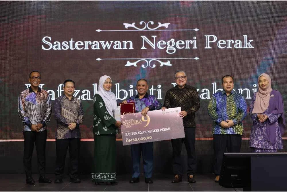 Saarani (tengah) menyampikan Anugerah Sasterawan Negeri Perak dkepada novelis dan cerpenis, Hafizah Iszahanid sempena Majlis Anugerah Hadiah Sastera Darul Ridzuan Ke-9 pada Sabtu.