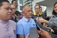 Awang Ahmad Sah (tengah) bersama penduduk ketika ditemui pemberita. 