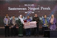 Saarani (tengah) menyampikan Anugerah Sasterawan Negeri Perak dkepada novelis dan cerpenis, Hafizah Iszahanid sempena Majlis Anugerah Hadiah Sastera Darul Ridzuan Ke-9 pada Sabtu.