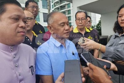 Awang Ahmad Sah (tengah) bersama penduduk ketika ditemui pemberita. 
