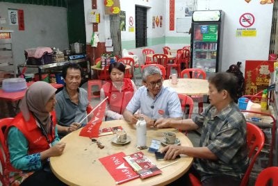 Tengku Zafrul (dua kanan) dan Noorzunita (kiri) beramah mesra dengan penduduk sekitar Kuala Pilah ketika Program Walkabout pada Sabtu.