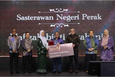 Saarani (tengah) menyampikan Anugerah Sasterawan Negeri Perak dkepada novelis dan cerpenis, Hafizah Iszahanid sempena Majlis Anugerah Hadiah Sastera Darul Ridzuan Ke-9 pada Sabtu.
