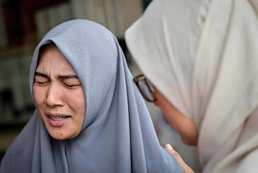 Ibu mangsa, Nor Azera Ismail, 36, tidak dapat menahan kesedihan. Foto Bernama