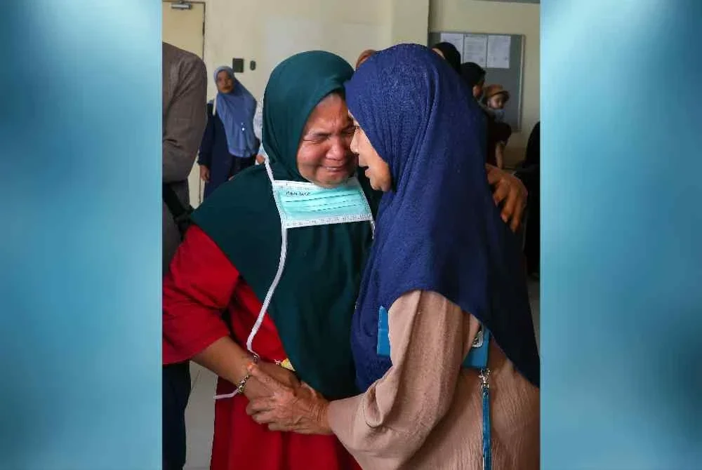 Rozita Ramli, 47, (kiri) tidak dapat menahan sebak.Foto Bernama