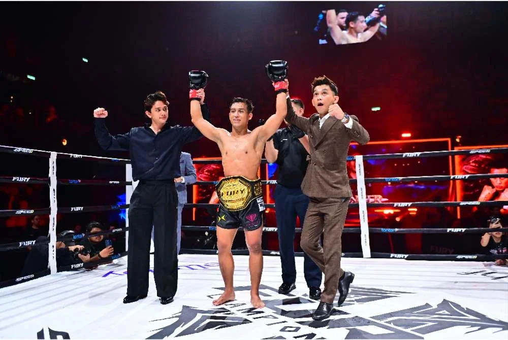 CEO Fury Championship, Mohd Wafiy (kiri) dan Ketua Pegawai Pemasaran Fury Championship, Mohamad Faizal Ahmad atau Jaa Suzuran meraikan kejayaan Izat merangkul tali pinggang Fury Muay Thai Lightweight Championship selepas menewaskan Brian Lawitan di Karisma Arena, Seremban.