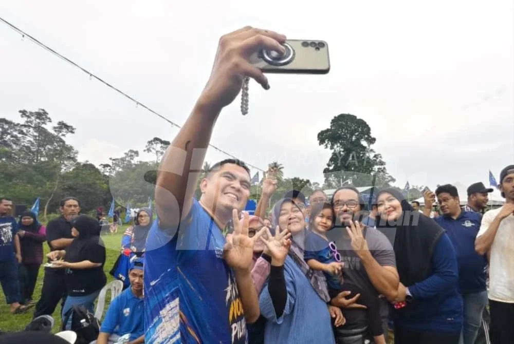 Muhamad Akmal melayani permintaan penyokong BN di Program Santai Ngoca Sawah di Sungai Serai, Semerbok pada Ahad.