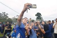 Muhamad Akmal melayani permintaan penyokong BN di Program Santai Ngoca Sawah di Sungai Serai, Semerbok pada Ahad.