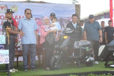 Mohamed Khaled Nordin (dua dari kiri) bersalaman dengan pemenang cabutan bertuah sempena Program Kesejahteraan Warga Angkatan Tentera Malaysia (ATM) Zon Selatan di Kem Sirusa di sini pada Ahad.