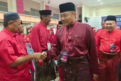Mohd Sharkar bersalaman dengan perwakilan selepas merasmikan Mesyuarat Perwakilan UMNO Bahagian Indera Mahkota kali ke-23 di Dewan Atabara Indera Mahkota pada Ahad.