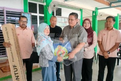 Mohamad Hilmi menyerahkan khemah kepada salah seorang peniaga terjejas di PPR Paya Nahu pada Ahad.