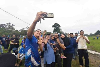Ketua Pemuda UMNO, Datuk Dr Muhamad Akmal Saleh ketika melayani permintaan penyokong BN di Program Santai Ngoca Sawah di Sungai Serai, Semerbok di sini pada Ahad.