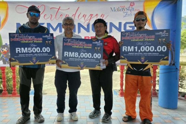 Rozaini (dua dari kanan) bergambar bersama pemenang pertandingan memancing sempena Kempen Tahun Melawat Malaysia di Pantai Lumut Waterfront pada Sabtu.