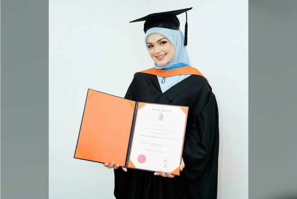 Siti Nurhaliza menunjukkan Ijazah Sarjana Kehormat Seni Kreatif dan Media yang diterimanya. - Foto: FB Siti Nurhaliza 