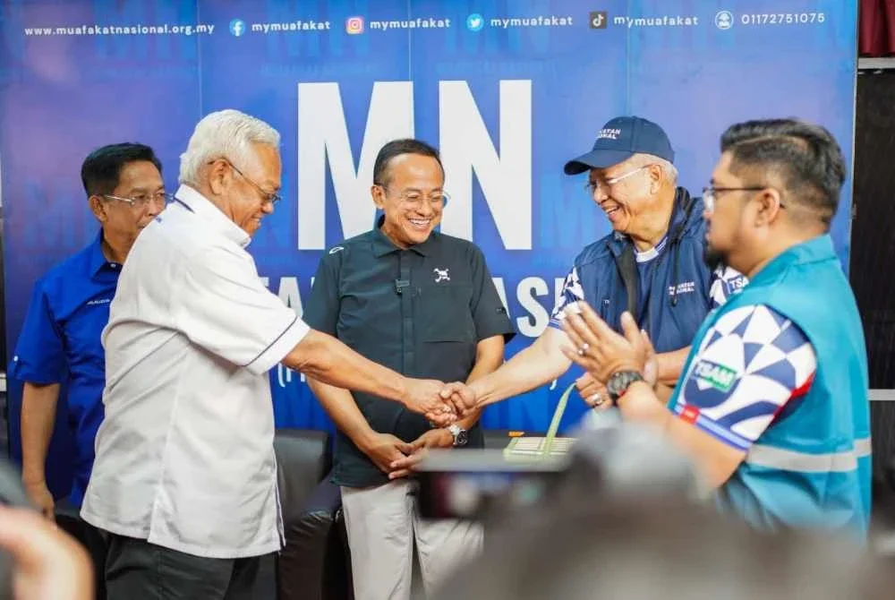 Annuar (dua, kanan) bersalam dengan Noh (kiri) sambil disaksikan beberapa pemimpin termasuk Ahmad Samsuri (tengah). Foto Facebook Annuar Musa