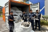 Roslan (dua dari kanan) menunjukkan 180 guni sirip ikan yu yang dirampas di Pelabuhan Klang pada 2 Julai lalu. 