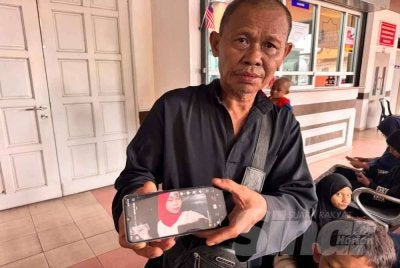 Mohd Said menunjukkan gambar Nur Atikah ketika ditemui pemberita di Jabatan Forensik Hospital Teluk Intan di sini pada Isnin.