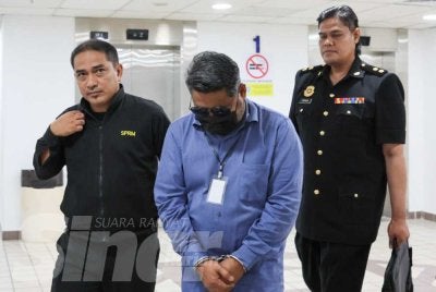 Yusri (tengah) dihadapkan ke Mahkamah Sesyen di Kuala Terengganu atas lima pertuduhan menerima wang suapan berjumlah RM12,200.