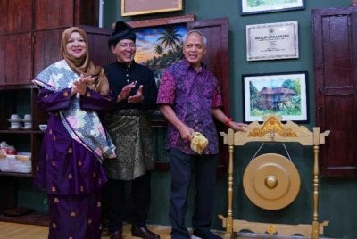 Muhammad Nasir (kanan) menyempurnakan gimik perasmian Warung Jendela Kaseh sambil diperhatikan Wan Rafidah di Worldwide Business Park, Seksyen 13, Shah Alam pada Isnin.