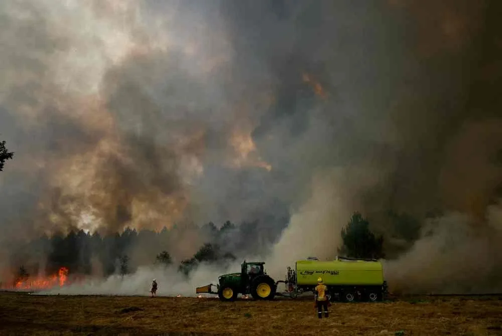 Pasukan bomba berhempas-pulas mengawal api daripada terus marak sejak minggu lalu. Foto Agensi