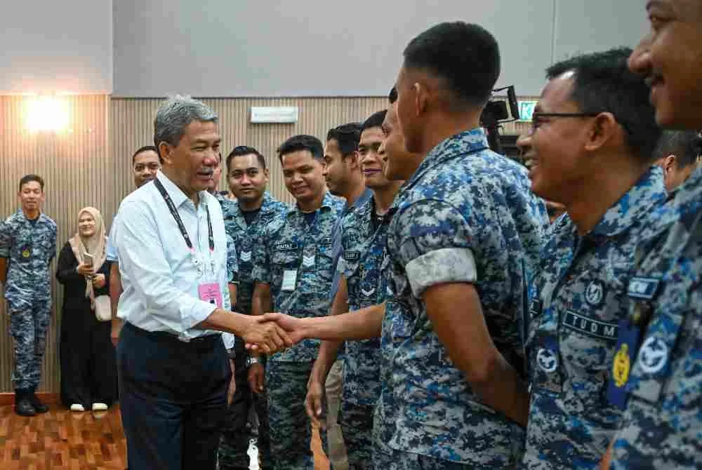 Mohamad beramah mesra bersama anggota TUDM ketika meninjau proses pengundian awal bagi PRN) Negeri Sembilan ke-16 di Pusat Pengundian Awal Dewan Angkasaraya Pangkalan Udara Sendayan, pada Selasa. Foto Bernama