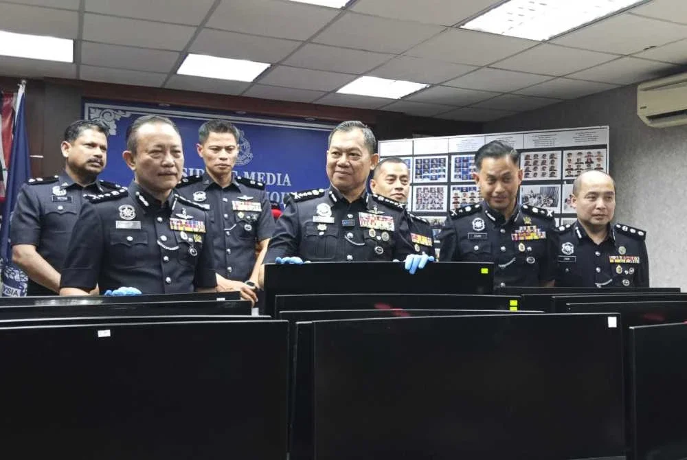 Ab Rahaman (tengah) menunjukkan barangan yang dirampas daripada sindiket calling center.