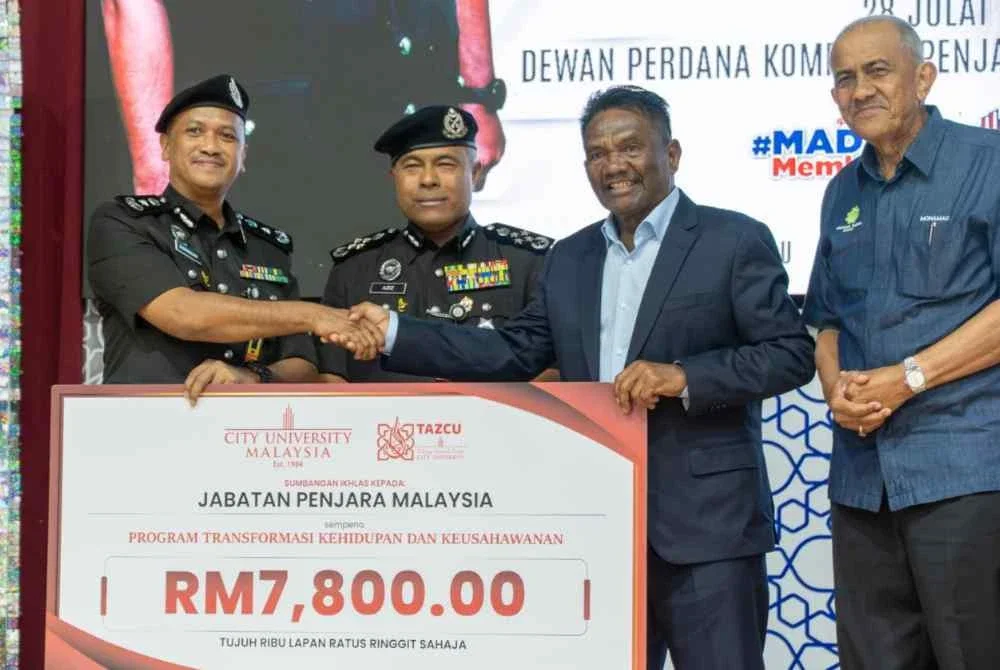 ProCanselor City Universiti, Datuk Mohamed Zaini Amran (kanan) menyampaikan sumbangan untuk Program Transformasi Kehidupan dan Keusahawanan kepada Pengarah Penjara Bentong, Timbalan Komisioner Penjara, Suhaizak Ab Wahab.