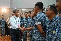 Mohamad beramah mesra bersama anggota TUDM ketika meninjau proses pengundian awal bagi PRN) Negeri Sembilan ke-16 di Pusat Pengundian Awal Dewan Angkasaraya Pangkalan Udara Sendayan, pada Selasa. Foto Bernama