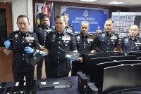 Ab Rahaman (dua dari kiri) menunjukkan barangan yang dirampas daripada sindiket calling center.
