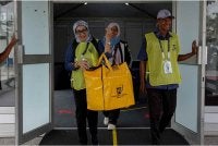Petugas SPR membawa beg berisi kertas undi selepas pusat pengundian awal ditutup pada jam 5 petang sempena PRN Negeri Sembilan ke-16 di Ibu Pejabat Polis Kontinjen Negeri Sembilan hari ini.
