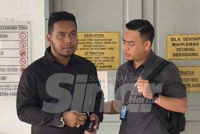 Abdullah Aqili (kiri) yang memakai baju kemeja berwarna hitam hadir ke Mahkamah Sesyen Sepang pada Selasa bagi menghadapi kes hantaran palsu. Foto Sinar Harian