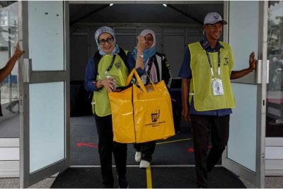 Petugas SPR membawa beg berisi kertas undi selepas pusat pengundian awal ditutup pada jam 5 petang sempena PRN Negeri Sembilan ke-16 di Ibu Pejabat Polis Kontinjen Negeri Sembilan hari ini.
