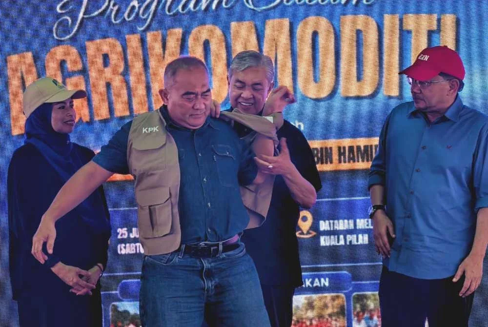 Ahmad Zahid memakaikan vest kepada Skuad Agrikomoditi Kuala Pilah.