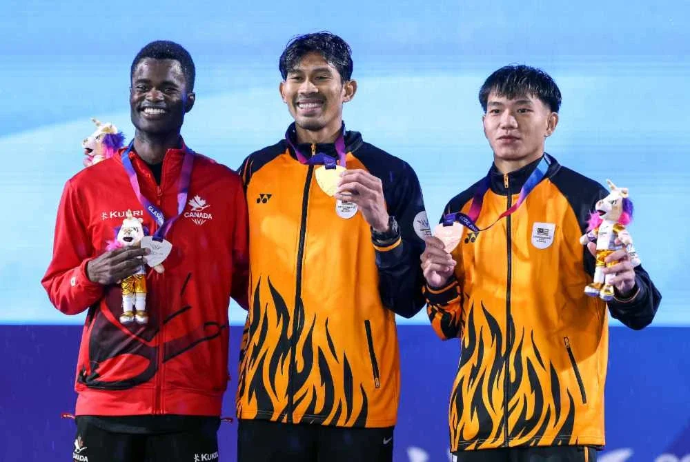 Abdul Latif (tengah) bersama pingat emas yang dimenanginya pada acara lompat jauh lelaki kategori T20 di temasya Sukan Komanwel Glasgow 2026 di Stadium Scotstoun. Pingat perak dimenangi atlet Kanada, Vucsics Noah (kiri) manakala pingat gangsa dimenangi atlet Malaysia, Gotuoh Eljoe (kanan). Foto Bernama