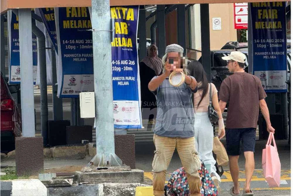 Syukur mengambil gambar wartawan yang merakam kegiatannya duduk di tepi jalan meminta sedekah. Foto: Sinar.