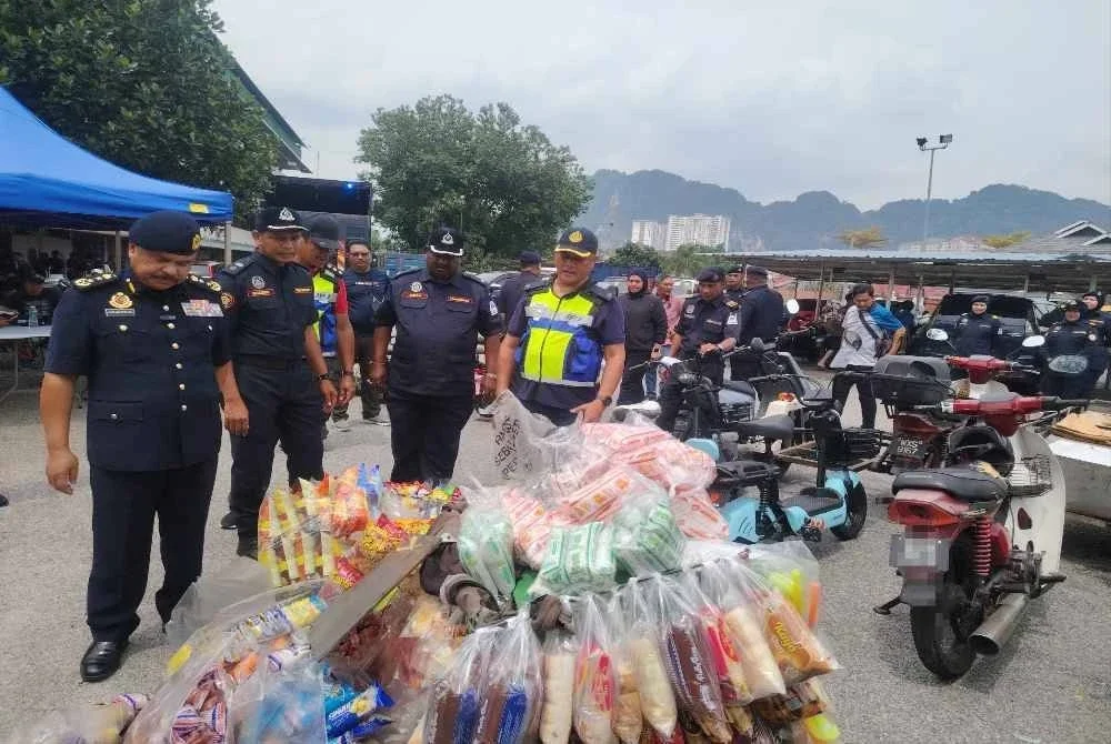 Ahmad Kamarunzaman (kiri) meninjau motosikal yang disita menerusi Op Pewa di sekitar Selayang pada Rabu.